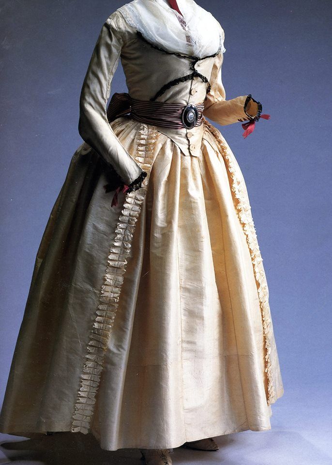 Silk – Serenity Sunday: Sharing one of my favorites – a 1790s Robe a L’Anglaise of cream silk taffeta  “two-layered “compères” front with buttons; matching trim; black lace decoration at front bodice and cuffs; wine-colored ribbon lacing at cuffs; matching petticoat; fichu at neck.”  Note also striped sash with metal buckle & painted porcelain center. *Wistful sigh* From the Kyoto Costume Institute | Facebook